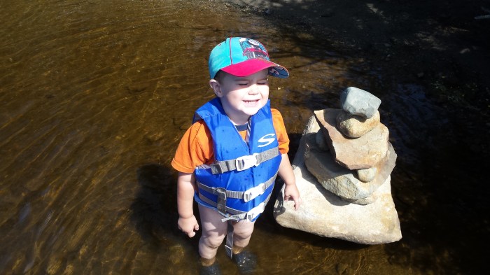 Smiling next to a rock pile someone built. Alden proceeded to add his own rocks to the display.